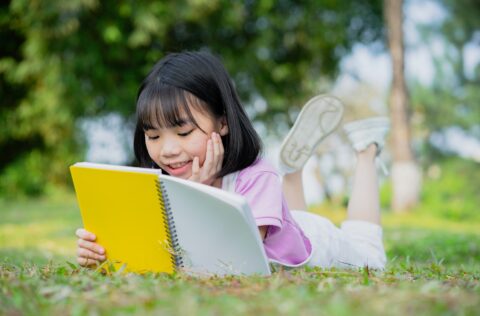 Asian little girl studying at park