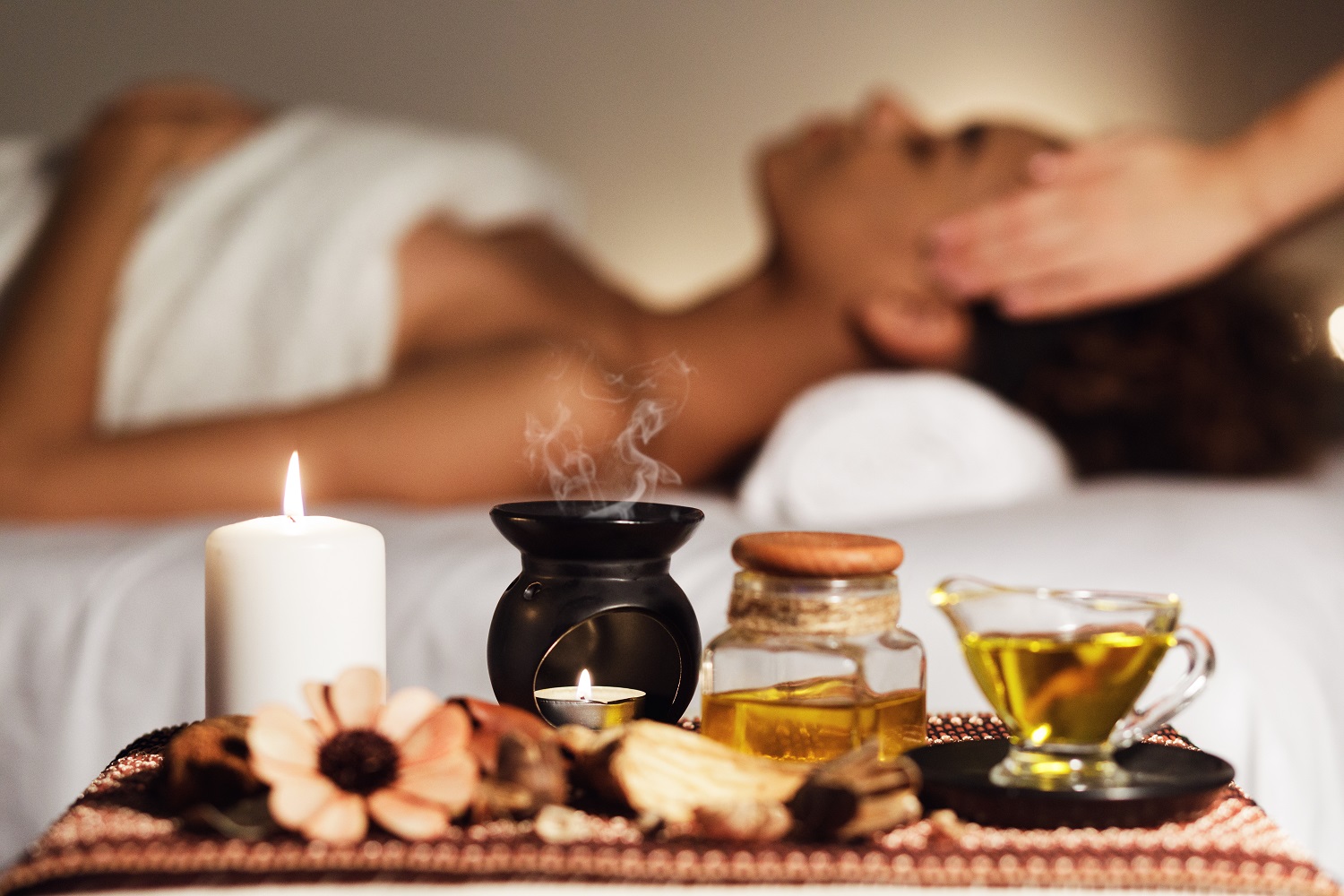 African woman having face massage, relaxing in spa salon