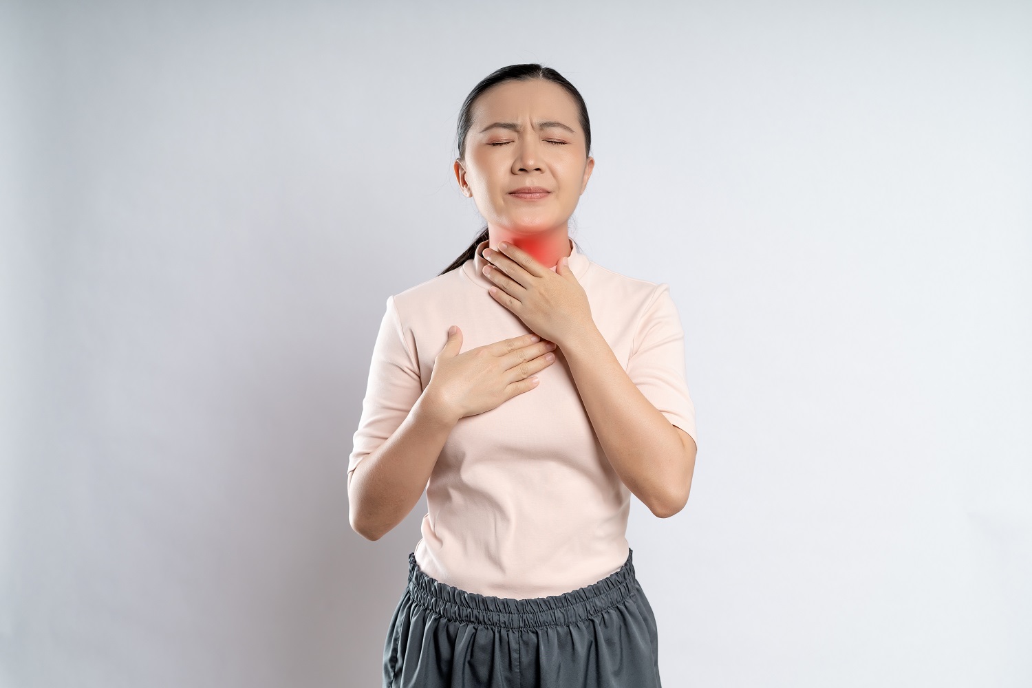 Asian woman was sick with sore throat and touching neck with red