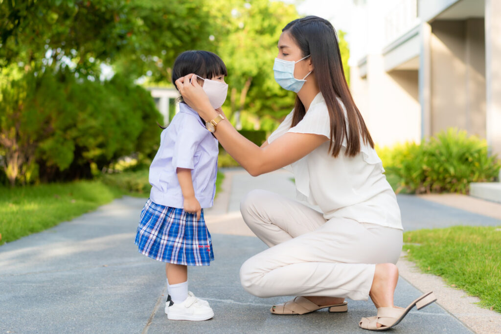 Seorang ibu memakai masker dan anaknya juga menggunakan masker